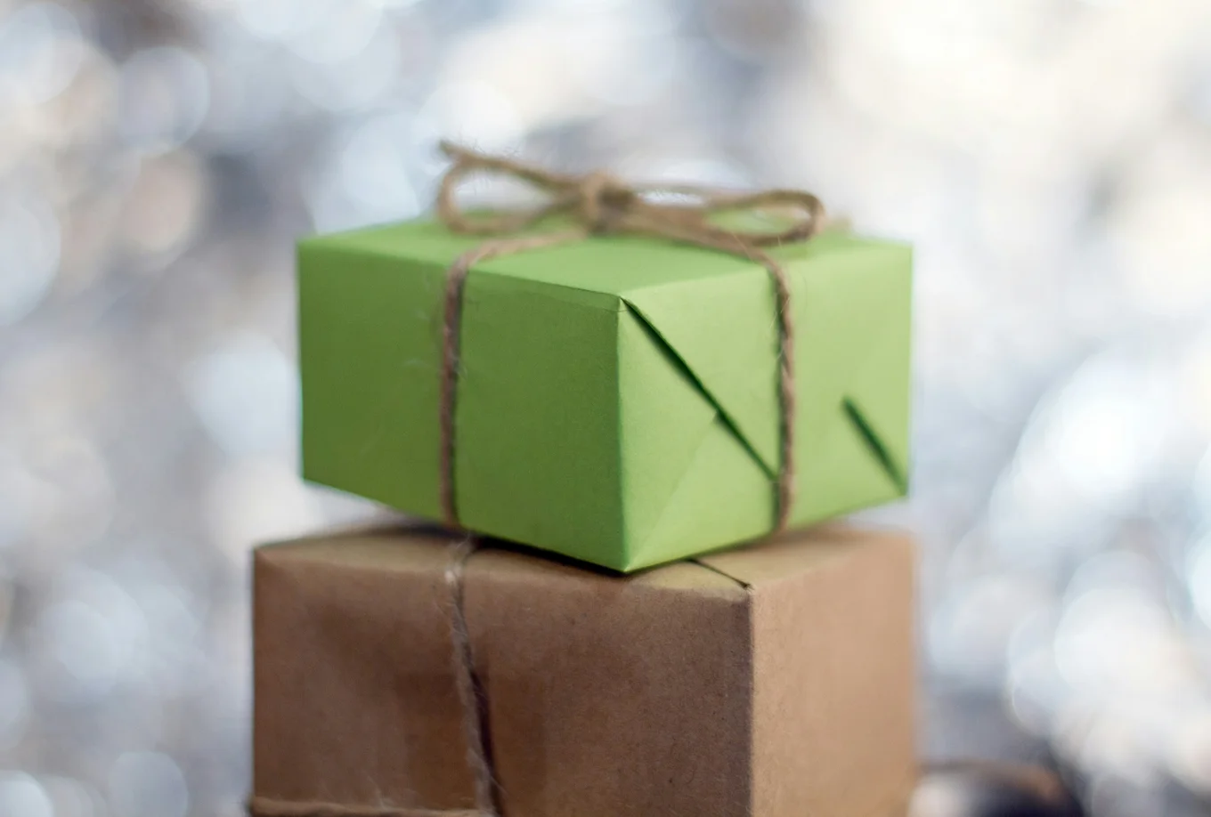 Two gift boxes, one green, one brown, tied with twine.