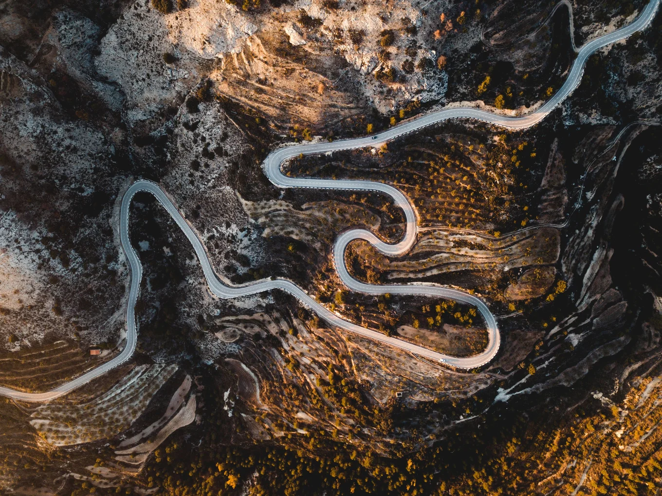 Winding road through a mountainous landscape, aerial view.